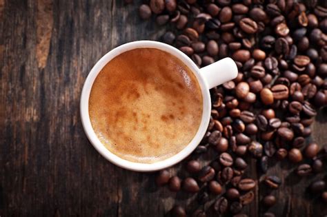 Premium Photo Cup Of Hot Coffee With Roasted Beans On Rustic Wooden