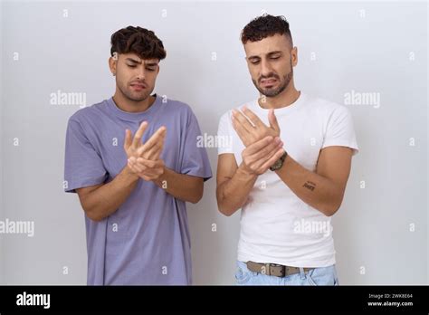 Homosexual Gay Couple Standing Over White Background Suffering Pain On