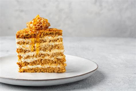 Slice Of Medovik Cake Decorated With Honeycombs And Flowing Drops Of