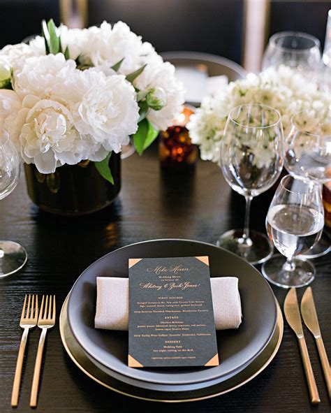 Dinner Tables Were Set In Black With Gold Accents And White Blooms