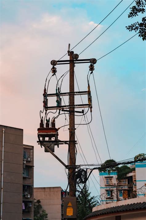 Wooden Electric Post Beside A Building · Free Stock Photo