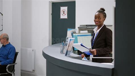 Portrait of African American Receptionist Working at Registration Desk ...