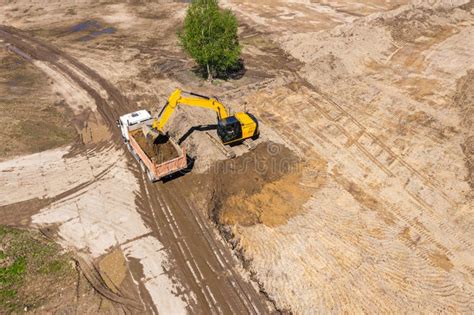 Industrial Excavator Loading Ground Into A Dump Truck On Construction