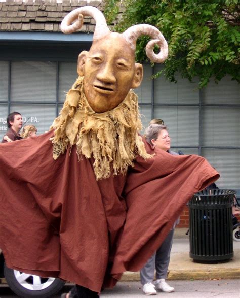 a man in a costume is walking down the street with an animal mask on ...