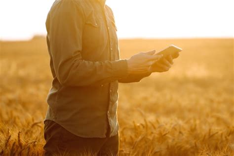 Agricultor con una máscara estéril con una tableta en las manos en un