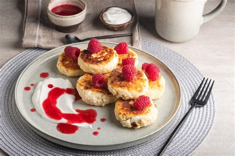 Premium Photo Cheesecakes Or Syrniki On A Round Plate With Raspberry