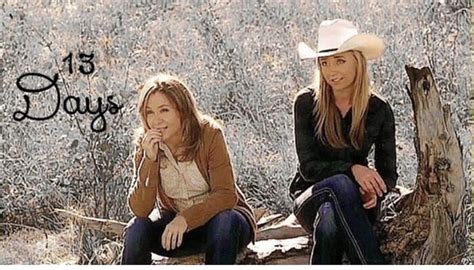 Two Women Are Sitting On A Log In The Woods One Is Wearing A Cowboy Hat