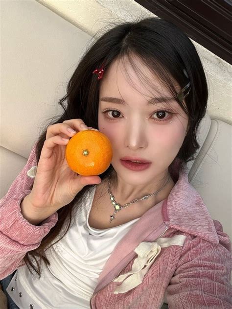 A Woman Holding An Orange In Her Right Hand