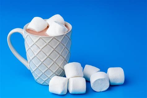 Premium Photo Cup Of Hot Cocoa Drink With Marshmallows On Blue Background