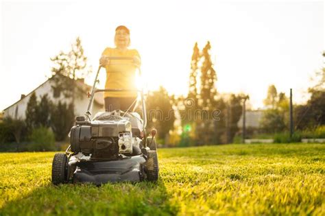 Portrait Of Beautiful 50s Senor Woman Cutting Grass With Gasoline Lawn