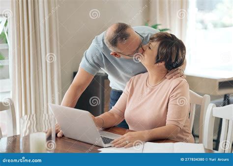 Im Your Eternal Cheerleader A Mature Husband Affectionately Kissing His Wife Stock Photo