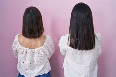 Hispanic Mother And Daughter Together Standing Backwards Looking Away