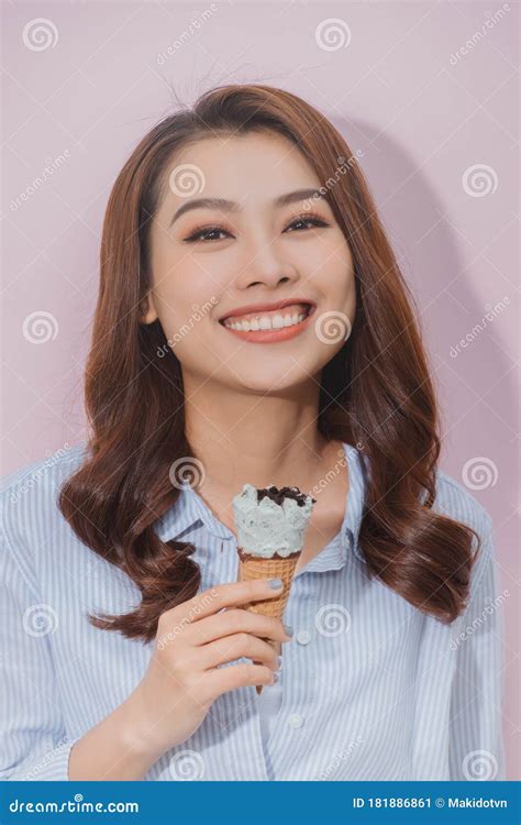 Young Woman Eats Ice Cream Cone And Looking At The Camera Stock Image