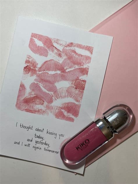 A Pink Lipstick Bottle Next To A Piece Of Paper With The Words Kiss