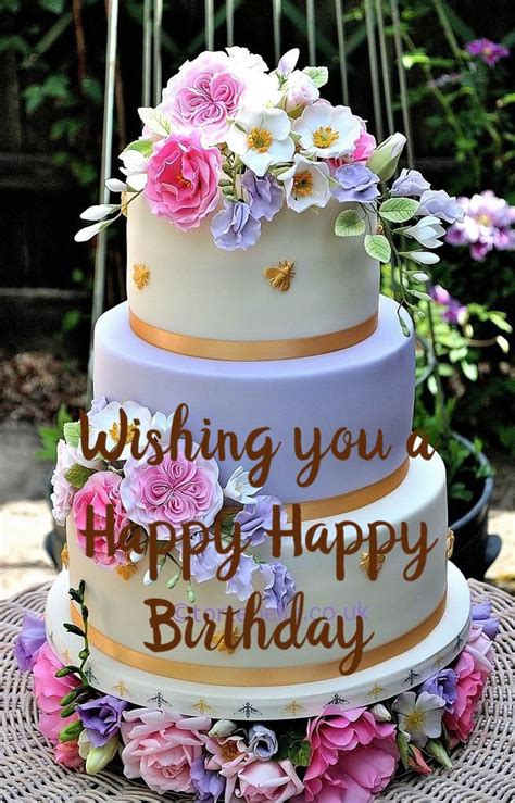 A Three Tiered Cake With Flowers On The Top And Writing Wishing You A