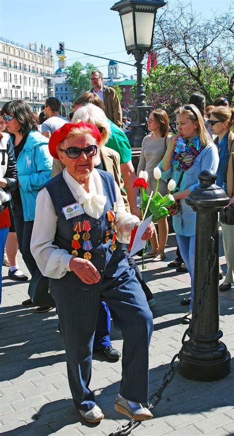 Portrait Of A War Veteran Woman Standing Holding Flowers Buds