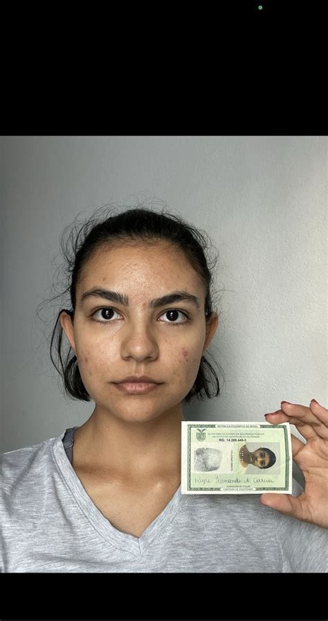 A Woman Holding Up A Dollar Bill In Front Of Her Face