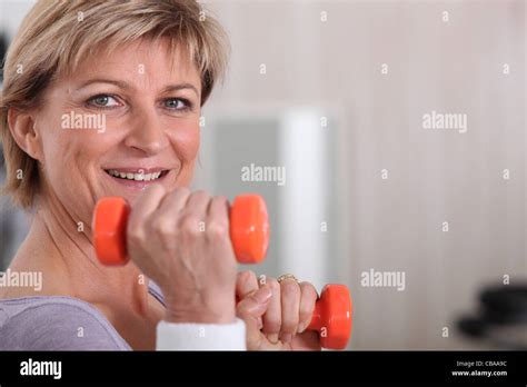 Mature Woman Using Dumbbells Stock Photo Alamy