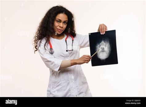 African American Female Doctor Examining X Ray Scan On Light Background