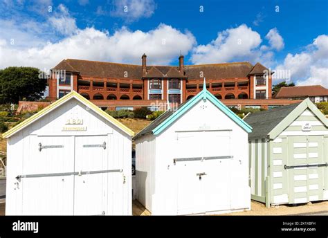 Colourful Beach Huts On Seafront Barlet Hospital Building Behind