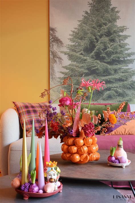 An Arrangement Of Flowers And Candles On A Coffee Table