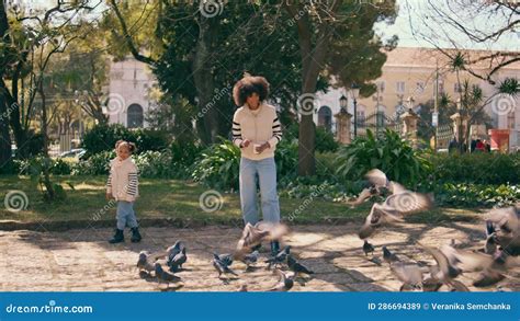 Mujer Tirando Palomas De Comida Paradas En Un Hermoso Parque Verde Con