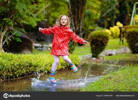 Child Playing In Puddle Kids Jump In Autumn Rain Stock Photo By