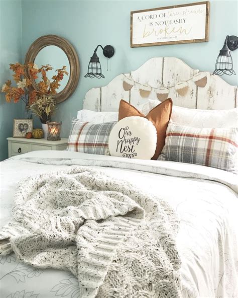 A White Bed Topped With Pillows And Blankets Next To A Wooden Headboard