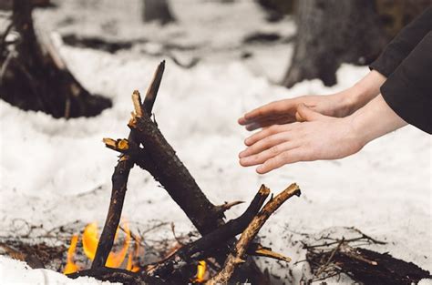 Premium Photo A Man Warms His Hands Near A Burning Bonfire In Winter