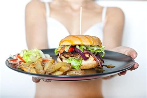 Premium Photo A Person Holding A Plate With A Burger And Fries