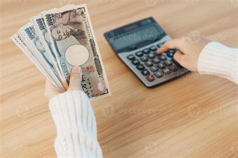 mano de mujer contando billetes de yen japonés con calculadora. dinero