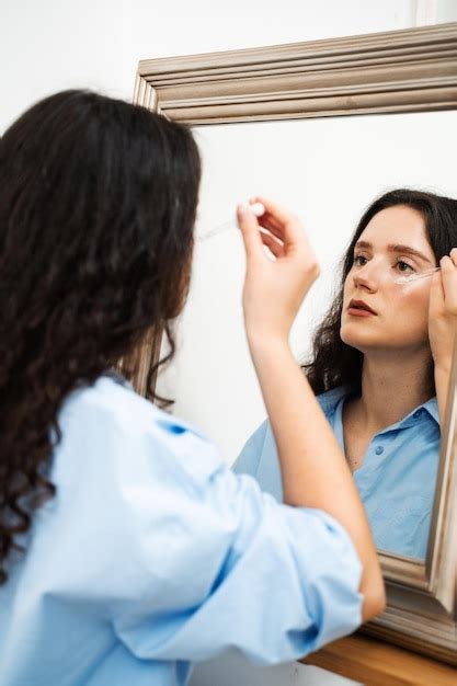 Premium Photo Young Woman Is Applying Moisturizing Serum On Skin Face