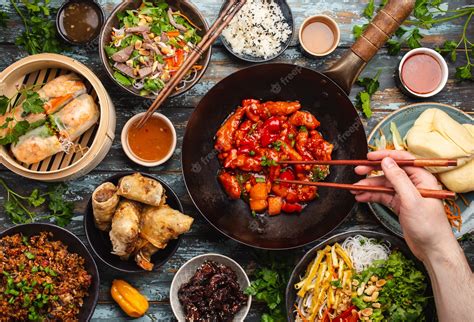 Premium Photo Set Of Assorted Chinese Food On Table With Male Hand Holding Chopsticks From