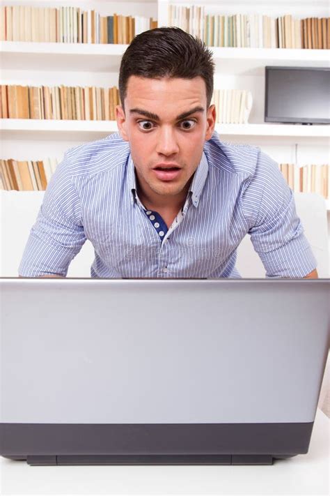 Homem Interessado Que Olha O Monitor Do Computador Chocado Imagem De