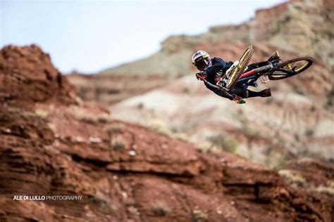 A Man Flying Through The Air On Top Of A Dirt Bike In Front Of A Mountain