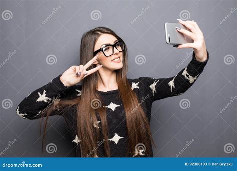 Joyful Young Women Making Selfie By Her Smart Phone On Grey Stock Image