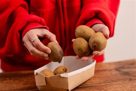 Premium Photo Woman S Hands Hold Whole Kiwis Showcasing The Benefits