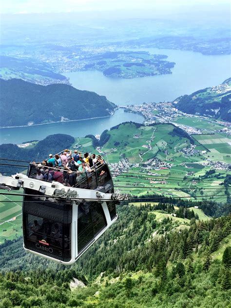 people are riding on the cable car over the valley and lake in the ...