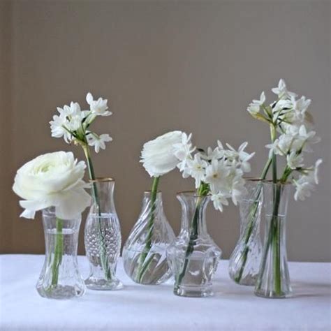 White Flowers In Vases Sitting On A Table