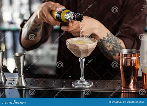 Male Bartender Pouring To The Measuring Glass Cup With Ice Cubes An