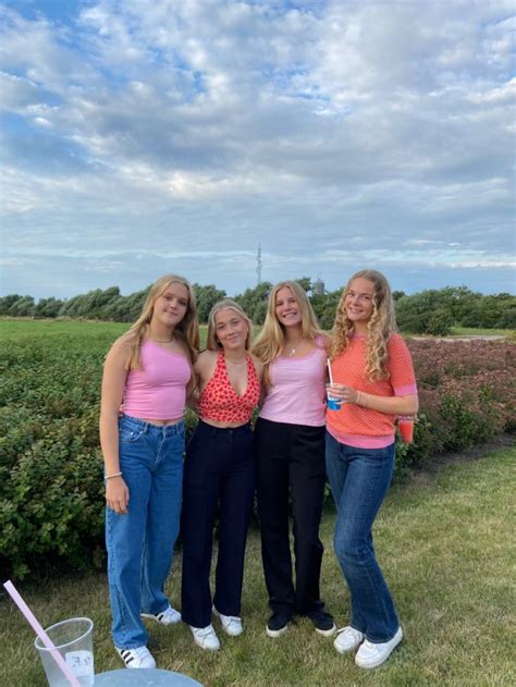 Four Girls In Pink Shirts And Jeans Posing For The Camera