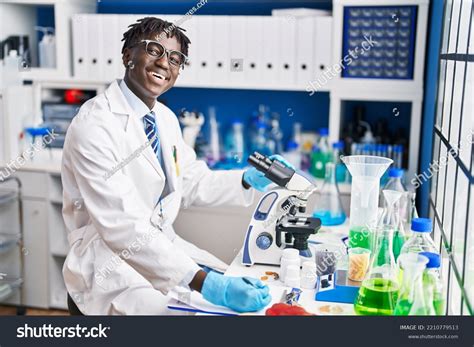 African American Man Scientist Using Microscope Stock Photo