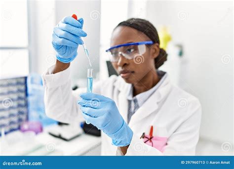 African American Woman Scientist Pouring Liquid On Test Tube At