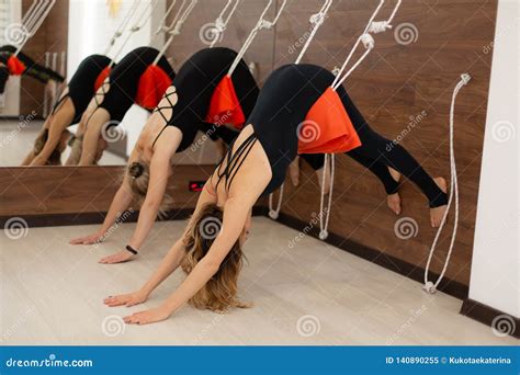 Women Practicing Yoga On Ropes Stretching In Gym Fit And Wellness