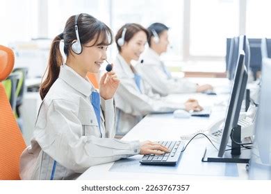 Smiling Telemarketing Asian Woman Working In Call Center Office