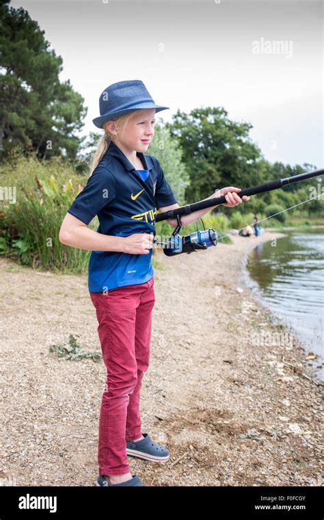 Jeune fille blonde de neuf ans la pêche à la mouche sur un lac Photo Stock Alamy