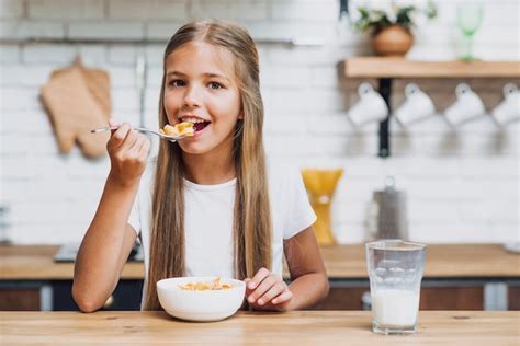 Fille Blonde Vue De Face Manger Ses Céréales Photo Gratuite