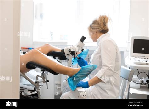 A Blond Woman Doctor Gynecologist Examines A Patient Who Is Sitting In A Gynecological Chair