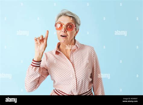 Mature Woman With Raised Index Finger On Color Background Stock Photo