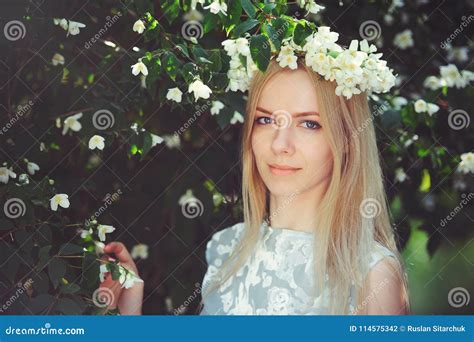 Het Aantrekkelijke Bescheiden Jonge Meisje Met Blonde Met Jasmijn Bloeit Kroon Op Hoofd Lang